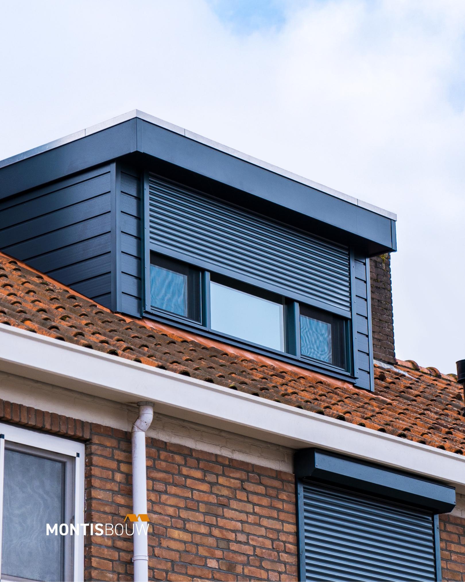 Afgewerkte dakkapel met donkerblauwe voorkant op bestaande woning met bakstenen muur