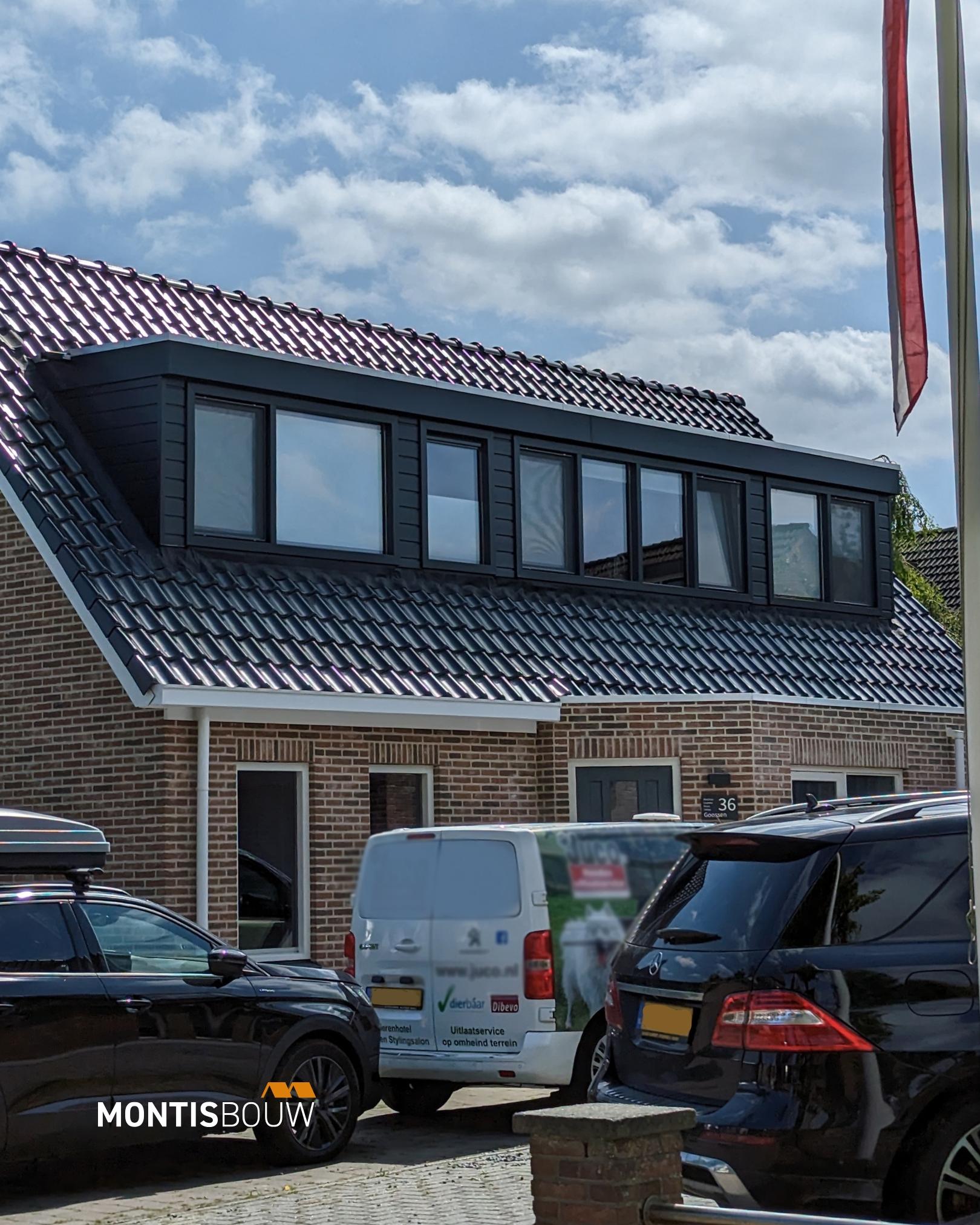 Bakstenen woning met moderne zwarte dakkapel en meerdere grote ramen