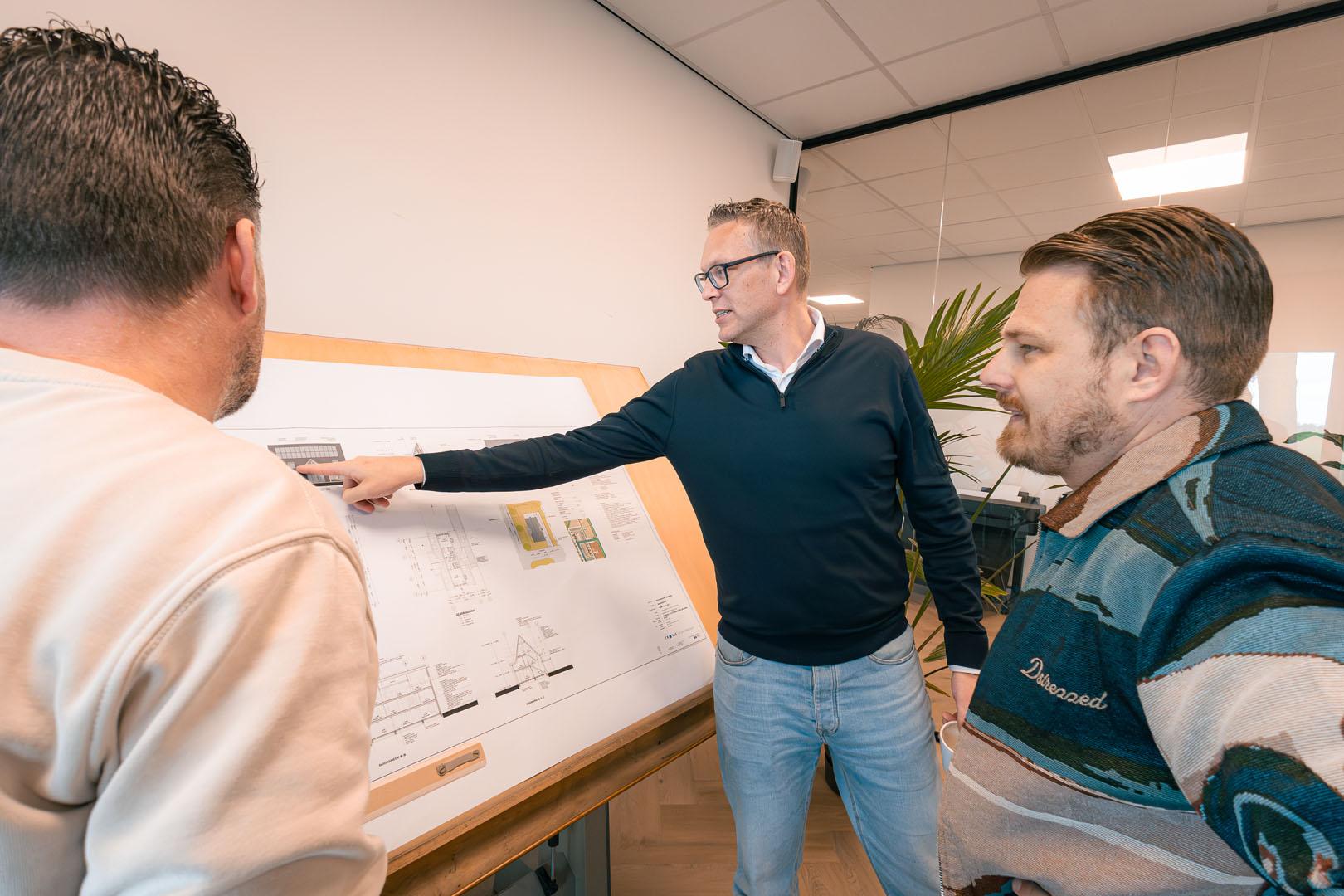 Team van Montis Bouw kijkt naar bouwtekeningen van een aanbouw