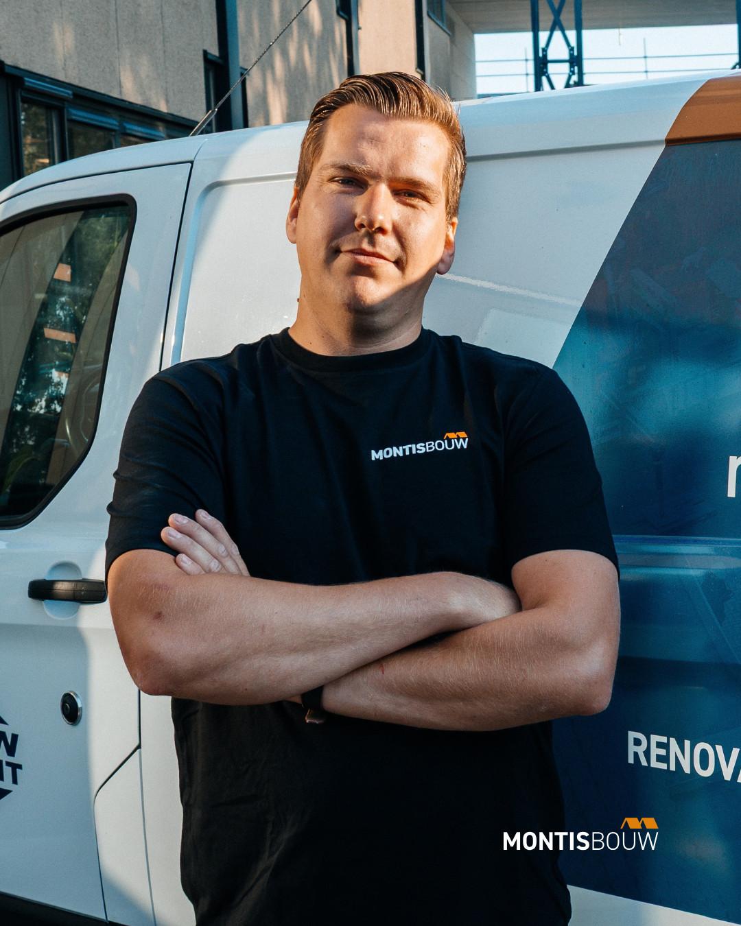 Medewerker met gekruiste armen voor bedrijfswagen Montis Bouw