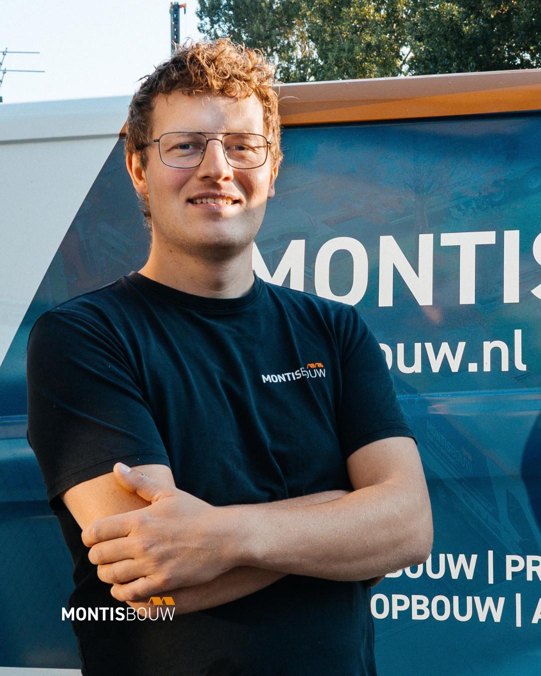 Man in Montis Bouw shirt voor bedrijfsvoertuig, gekruiste armen