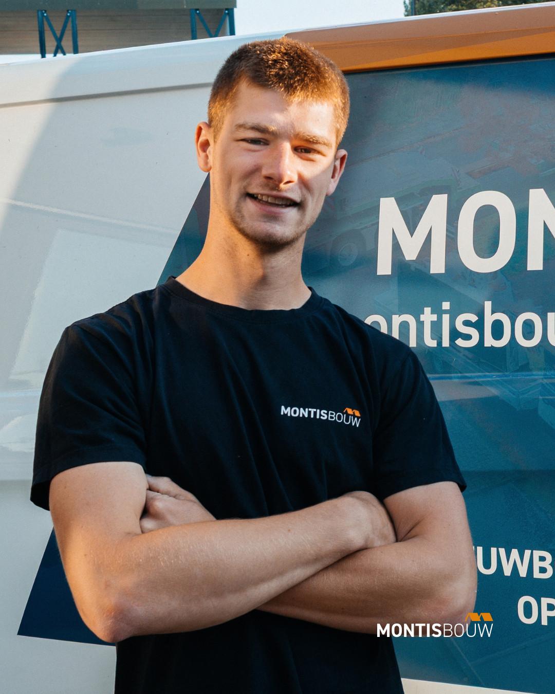 Man in Montis Bouw-shirt met gekruiste armen lacht naar camera