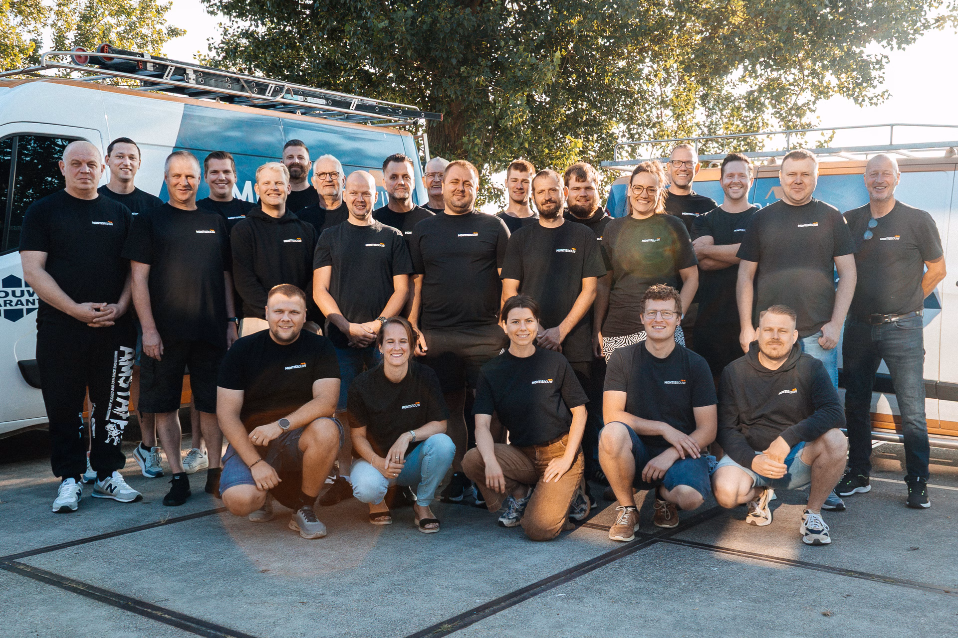 Groot team in bedrijfskleding poseren voor blauwe werkwagen